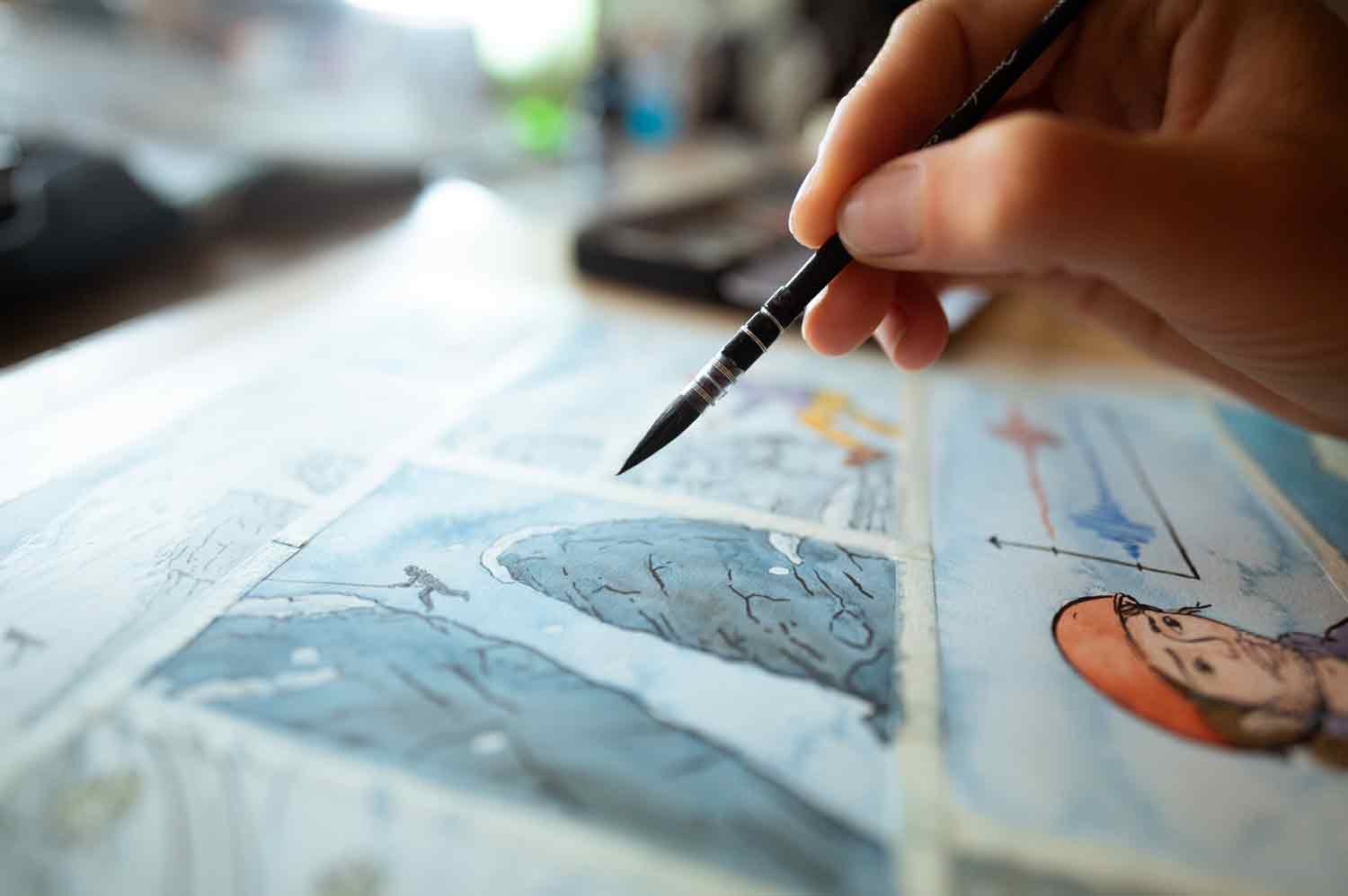 Un pinceau dépose la couleur sur une case de la bande dessinée.