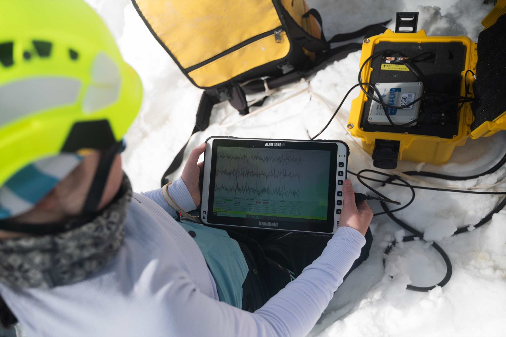 Consultation de mesures sur un ordinateur, avec les instruments installés sur la neige.